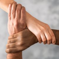 Top view of young people holding hands. Symbol and concept of unity, teamwork and support.